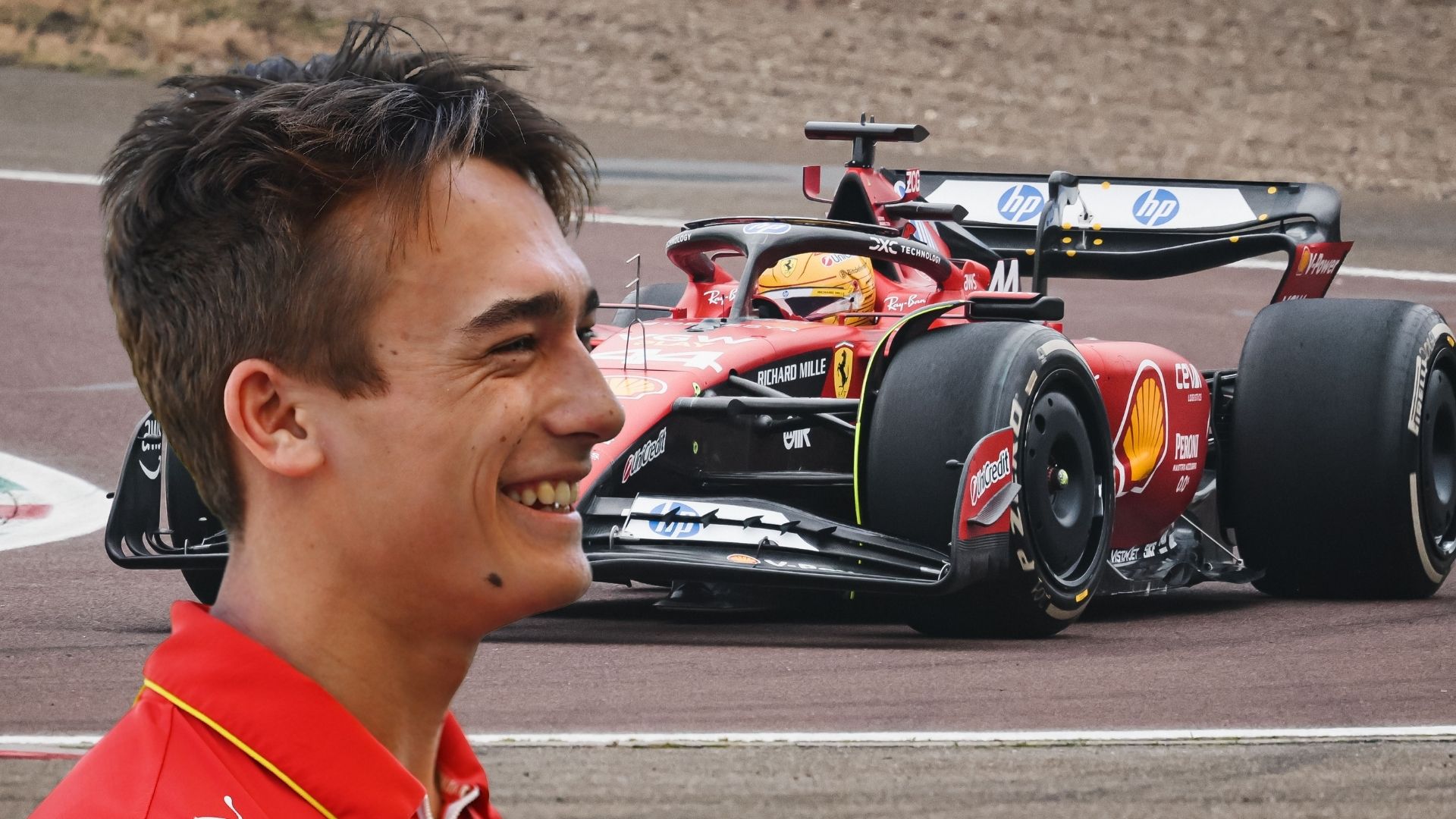 Dino Beganovic, leende i Ferraris teamkläder, med en Ferrari F1-bil i bakgrunden under tester på banan.