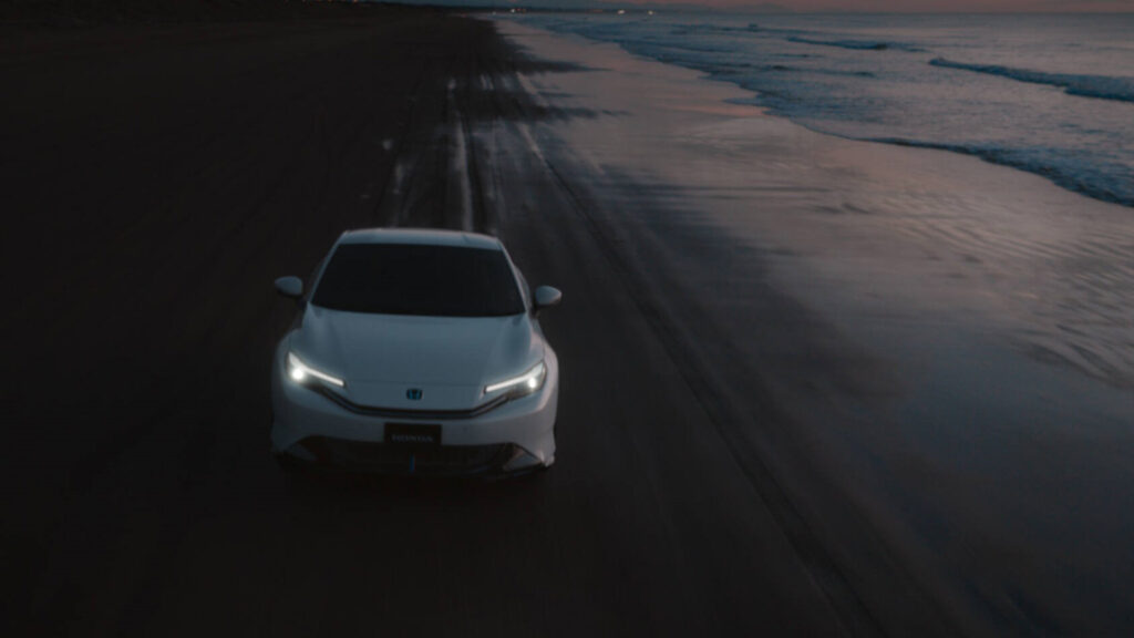 Drönarbild på Honda Prelude körandes på en strand. 