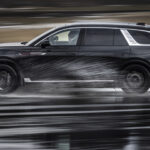 Svart Hongqi E-HS9 kör genom vattenpöl.