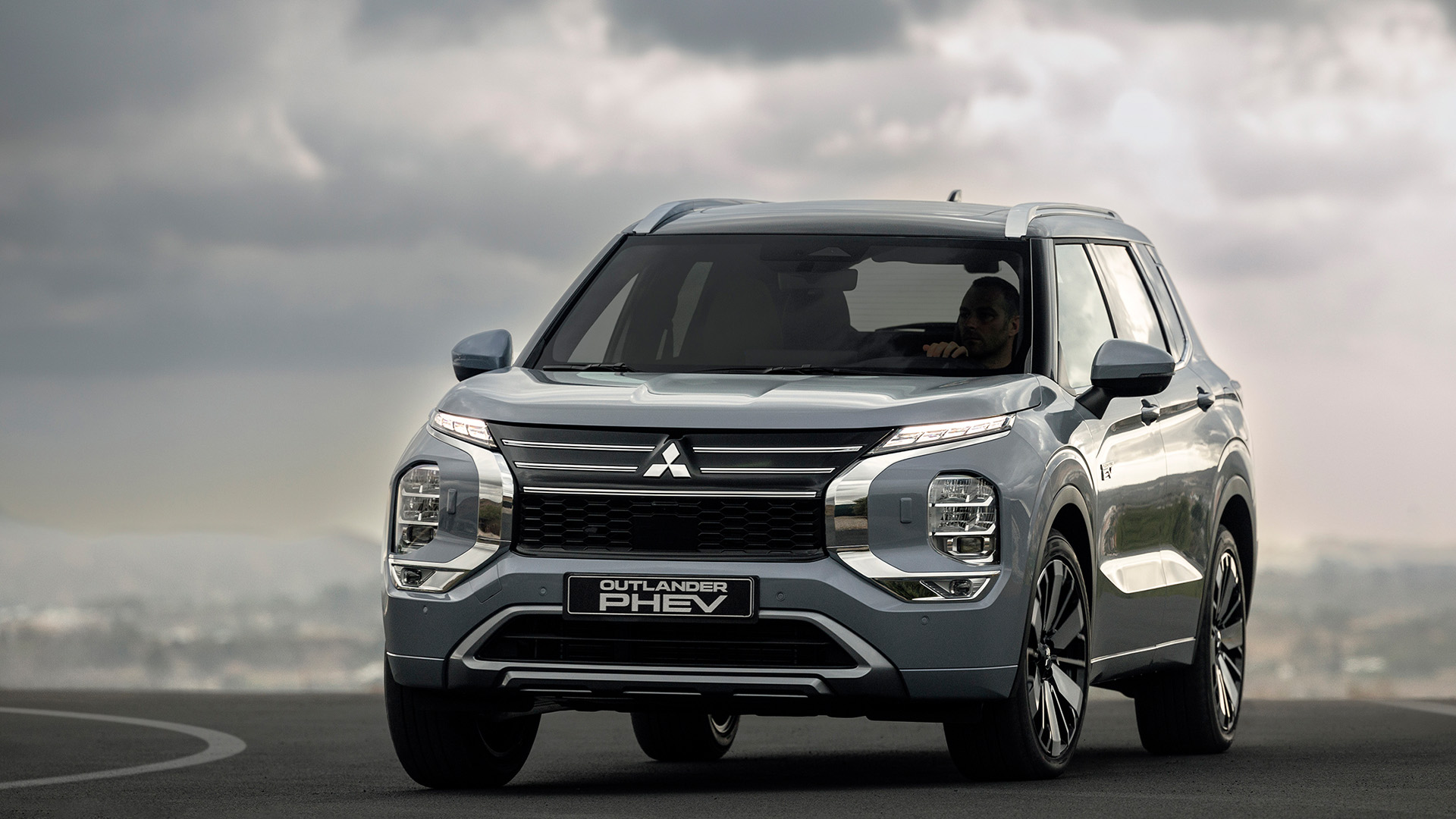 Mitsubishi Outlander Plug-in Hybrid mot molnig bakgrund.