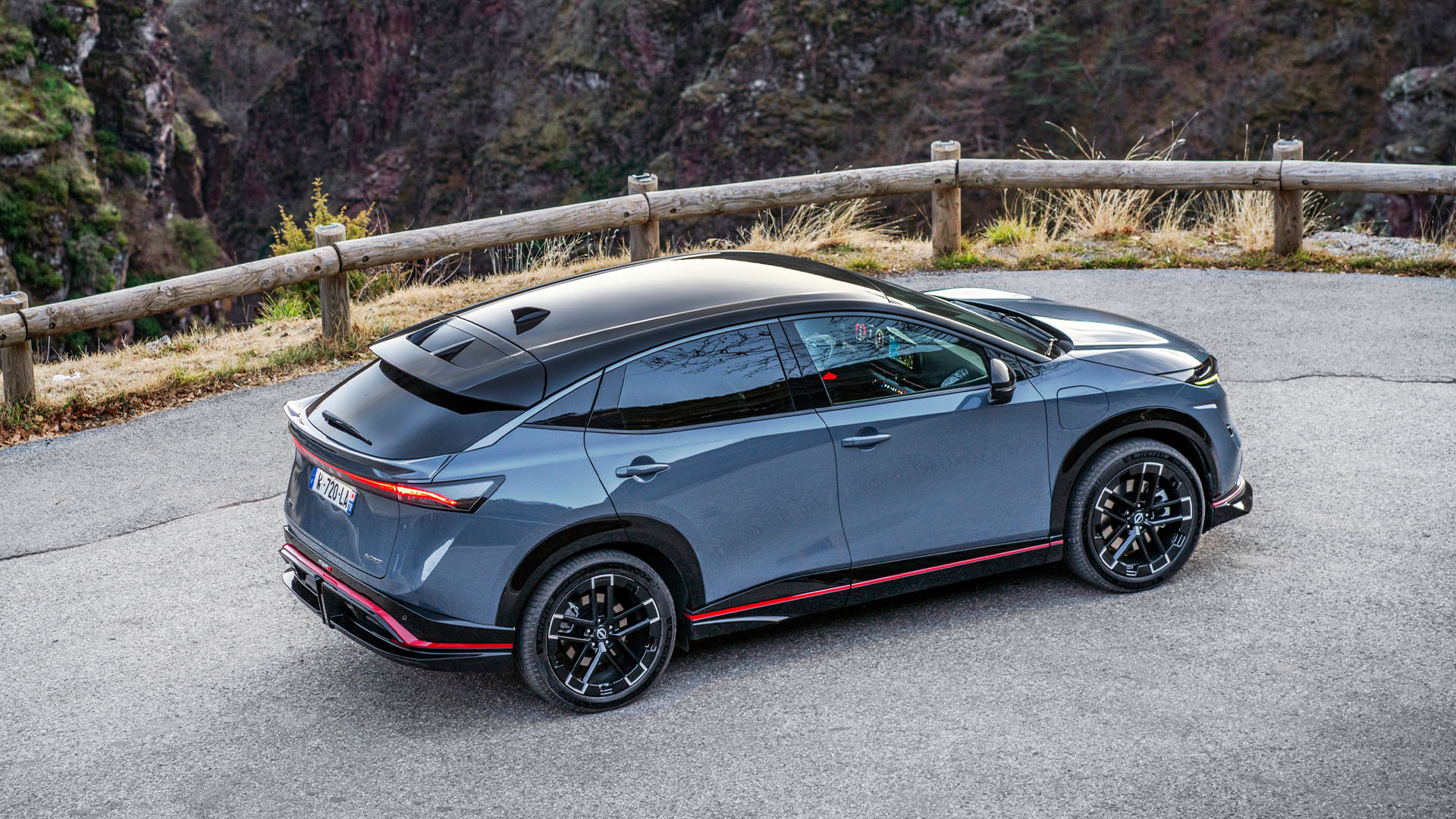 Nissan Ariya Nismo fotad lite uppifrån och visar bilen i profil.