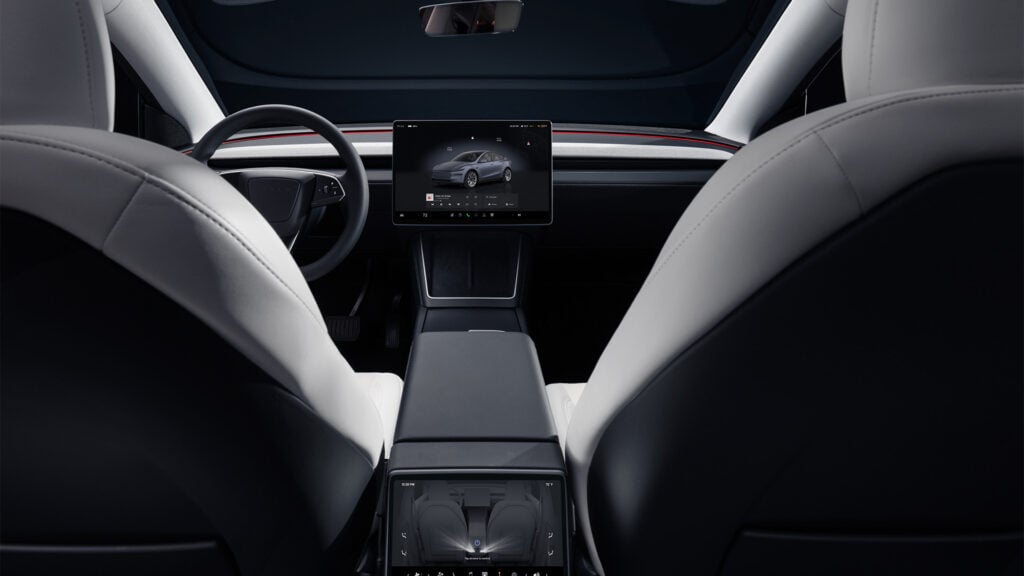Bild på interiören hos nya Tesla Model Y. Bild tagen från baksätet. 